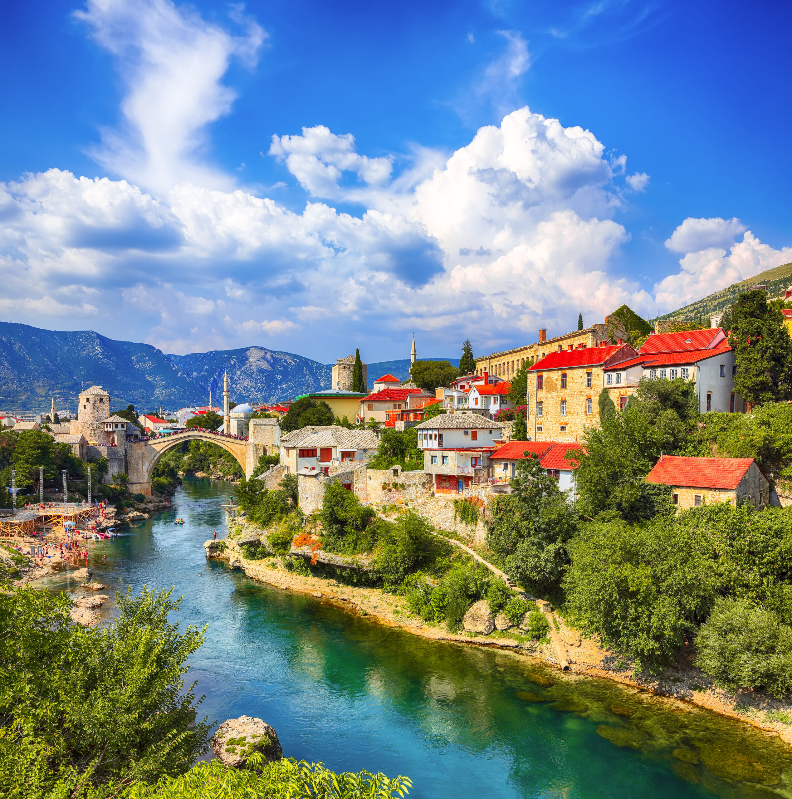 Fantastic Skyline of Mostar with the Mostar Bridge, houses and minarets, during sunny day. Location: Mostar, Old Town, Bosnia and Herzegovina, Europe