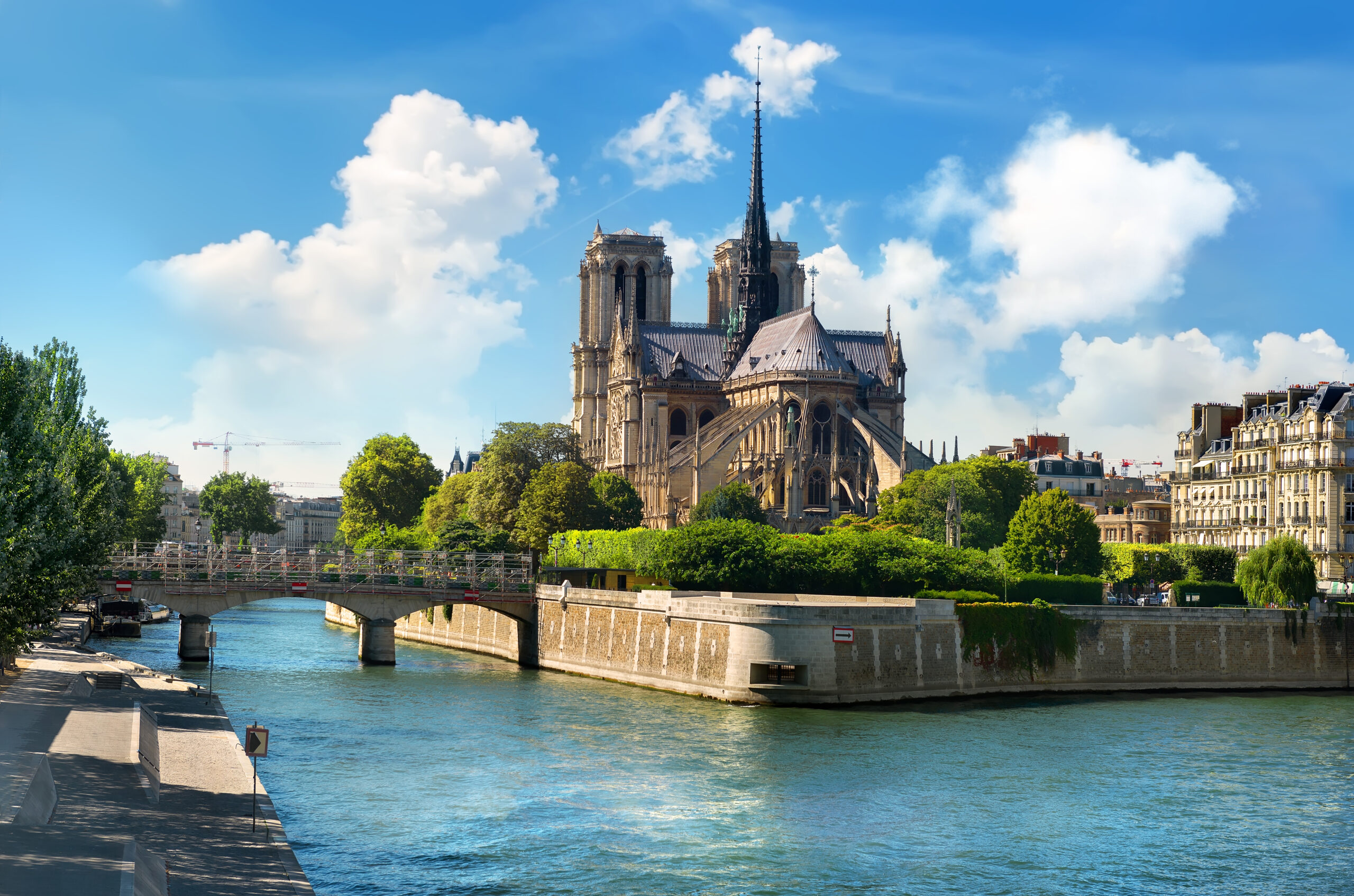 Notre Dame de Paris on river Seine and cloudy sky, France